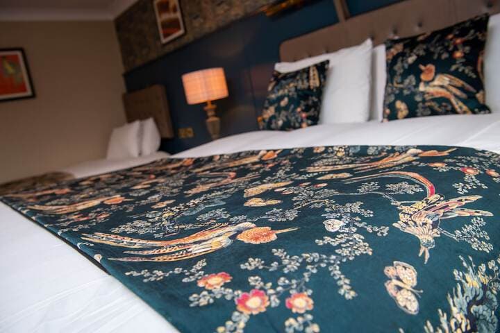 Floral-patterned bedspread in stylish hotel room at Red Lion Todwick, Yorkshire.
