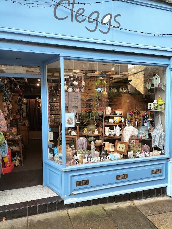 Colorful homeware store window featuring various decorative items, plants, and gifts, with a blue exterior.