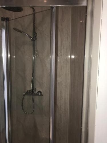 Modern shower with glass doors and sleek chrome fixtures in a Middlesbrough hotel bathroom.