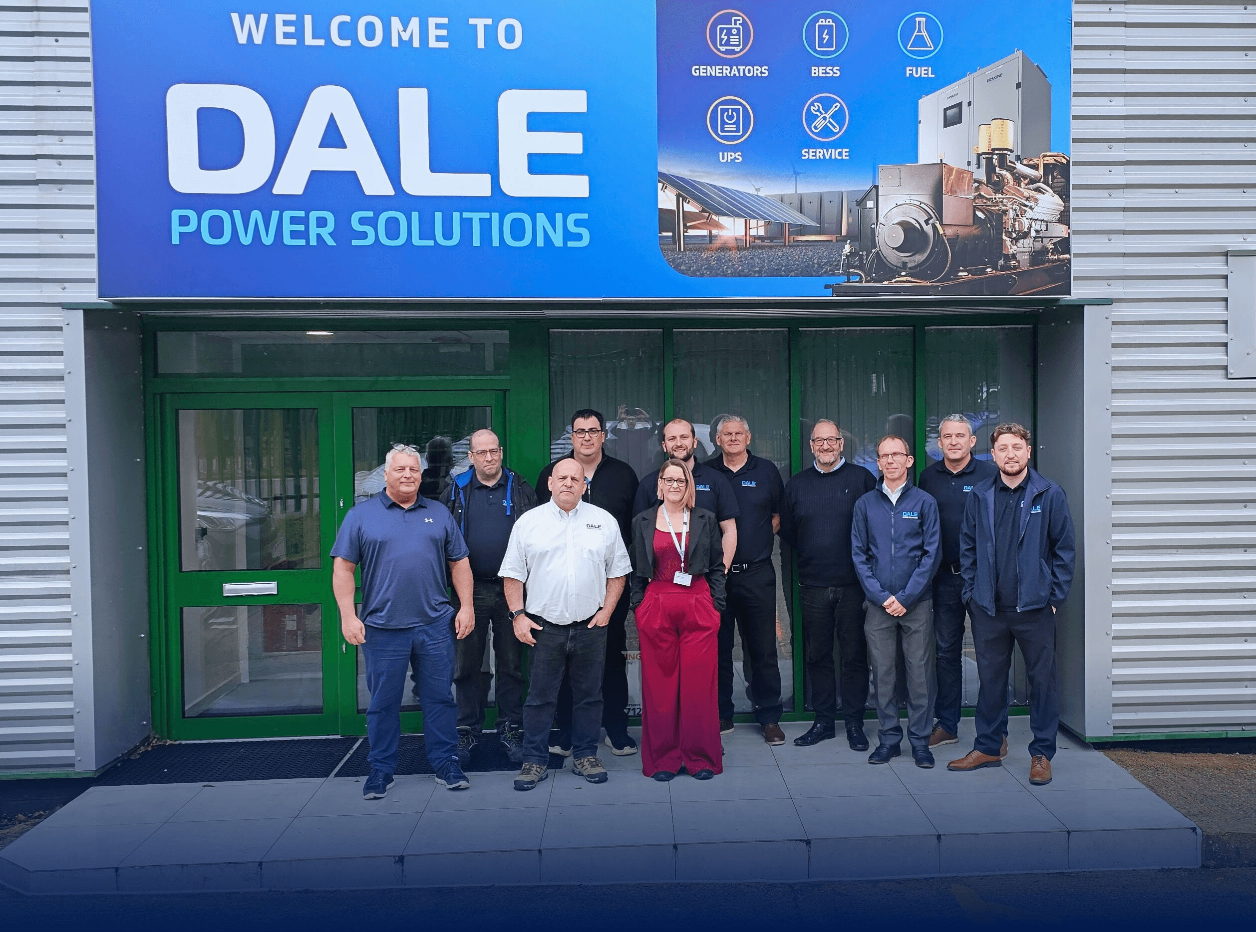 A diverse team of professionals stands proudly outside the new Dale Power Solutions hub, showcasing modern architecture and signage.