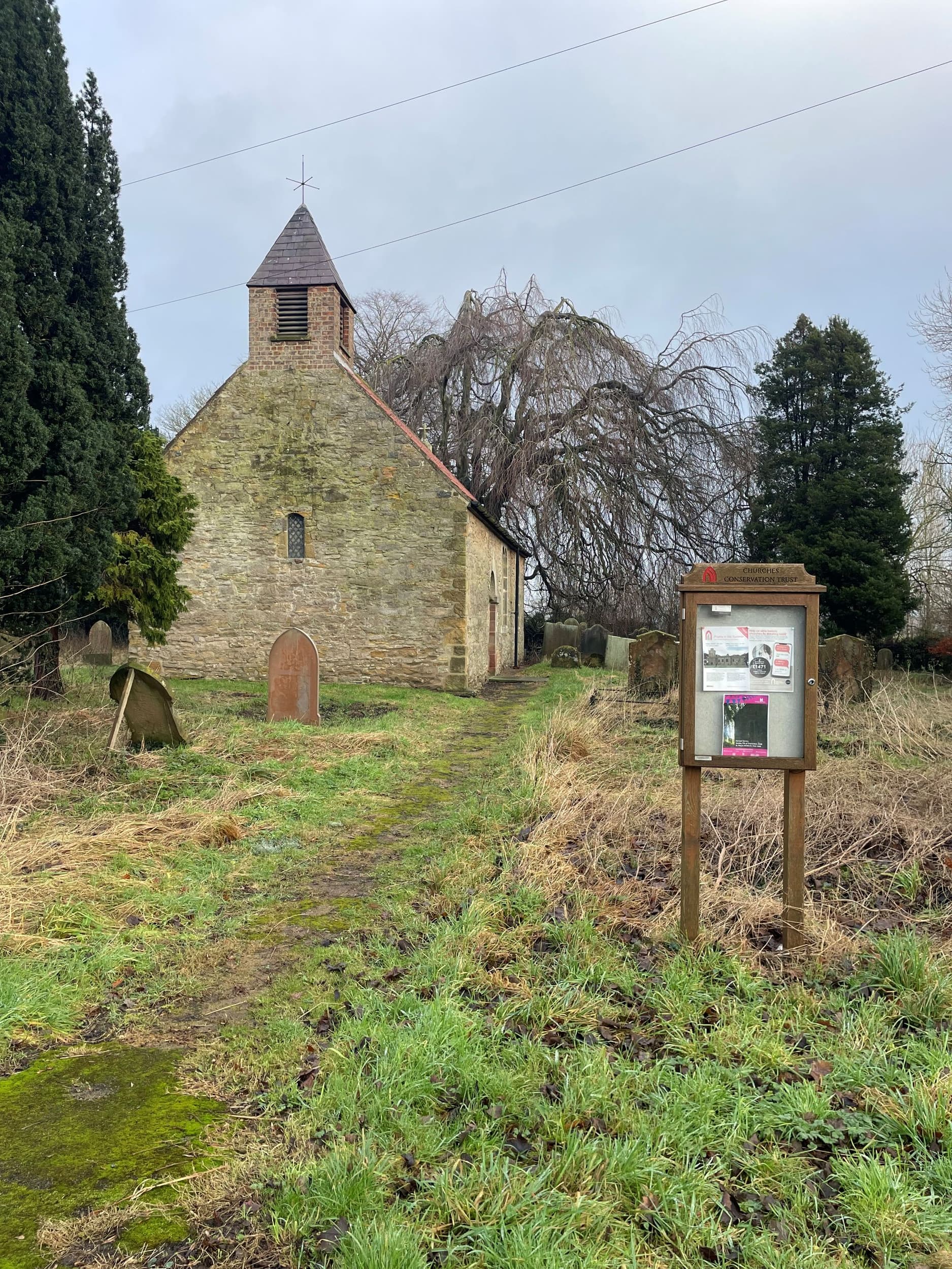 Historic stone chapel of St Mary's at Birdforth with bell tower surrounded by trees