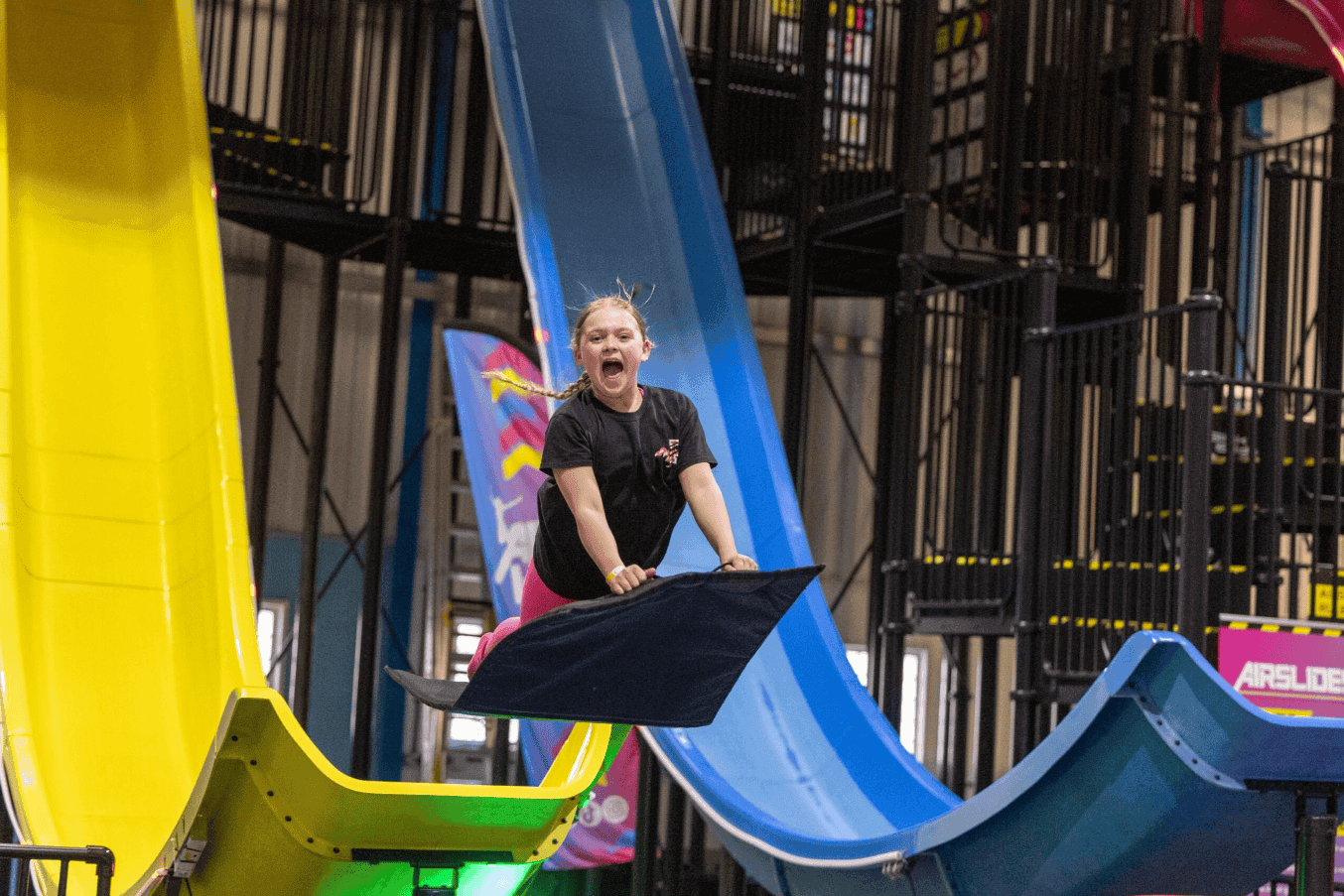 Child sliding down indoor slide with bright colors