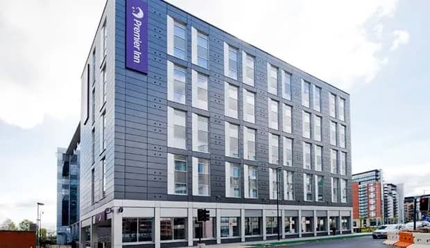 Modern hotel building with glass facade and purple signage