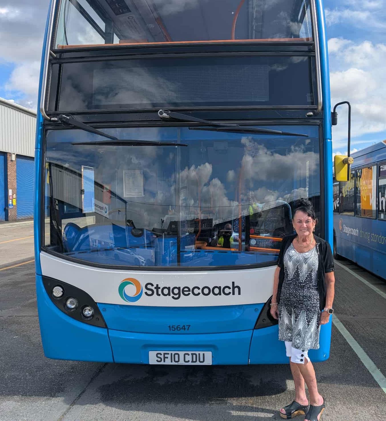Double-decker bus with Stagecoach logo and woman standing in front