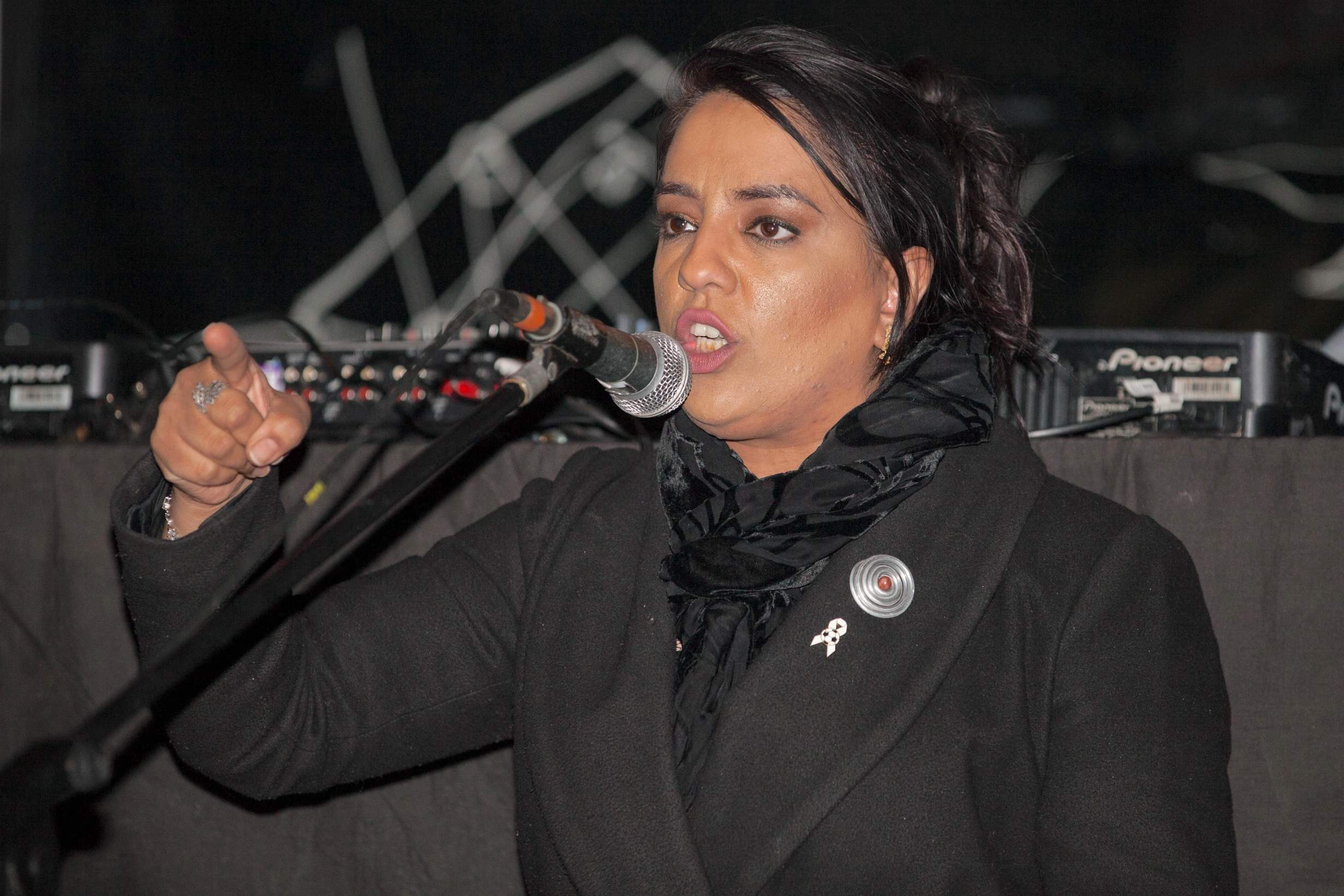 Person speaking passionately into microphone on stage