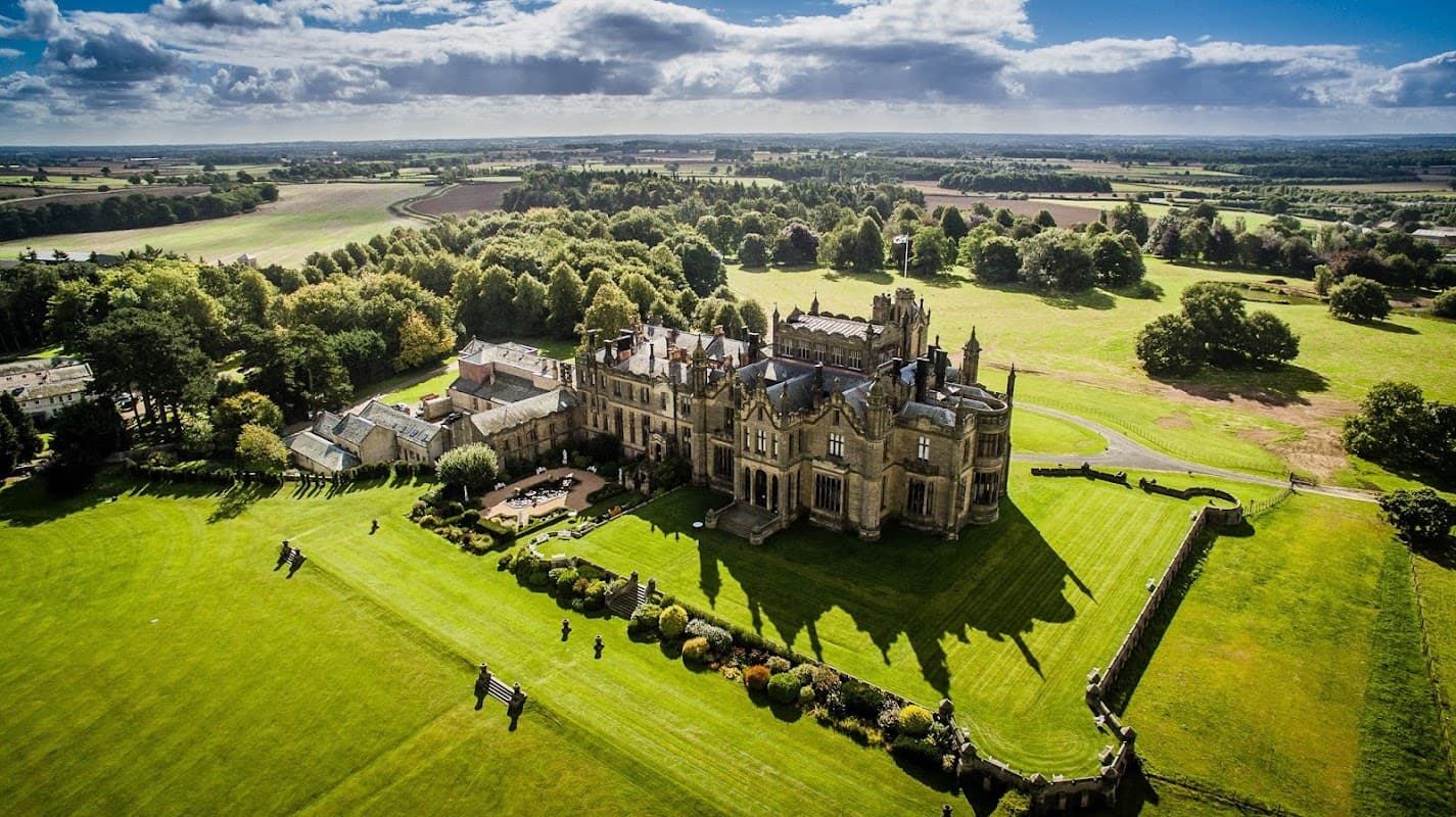 Aerial view of Allerton Castle, showcasing its grand architecture and surrounding green landscape in North Yorkshire.