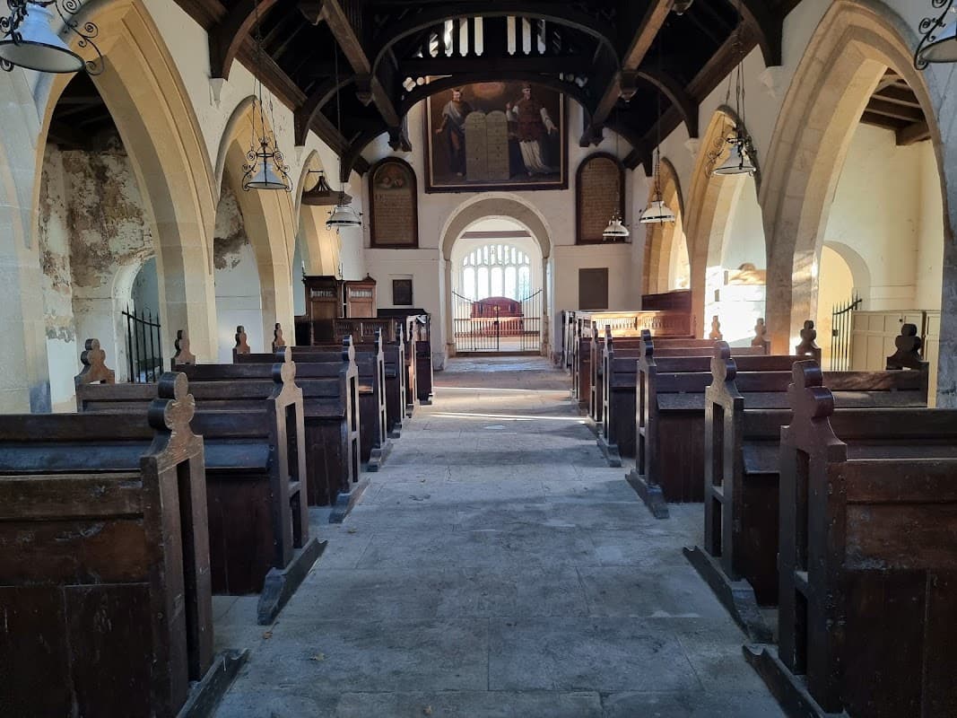 Interior of St Martin's Church with wooden pews, arched ceilings, and a large painting at the far end.