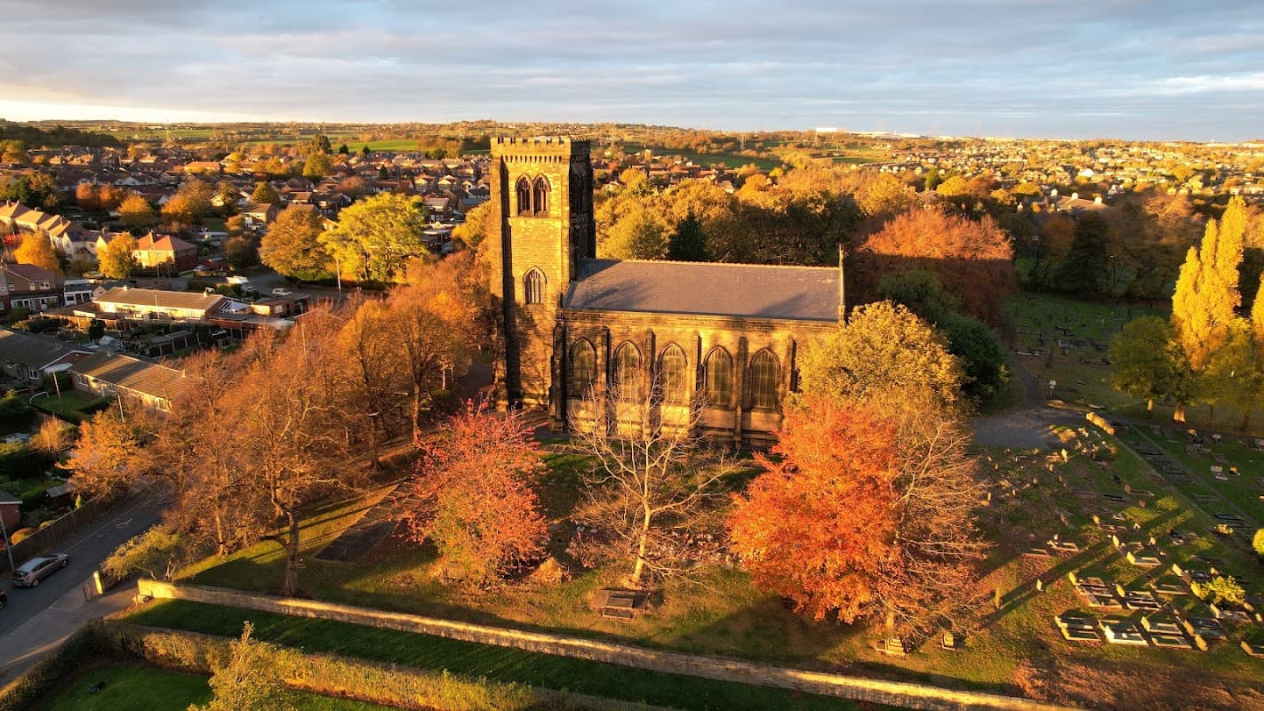 St Paul's Church surrounded by autumn trees and a cemetery, overlooking a residential area in Alverthorpe, Yorkshire.