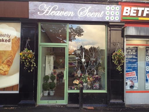 Heaven Scent Florist storefront with green door, floral displays, and hanging baskets in Apperley Bridge, Yorkshire.