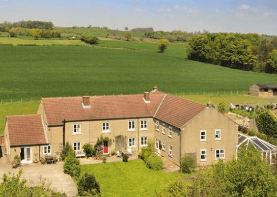 Elmfield House, a spacious guest house with a garden, surrounded by lush green fields and trees in Yorkshire.