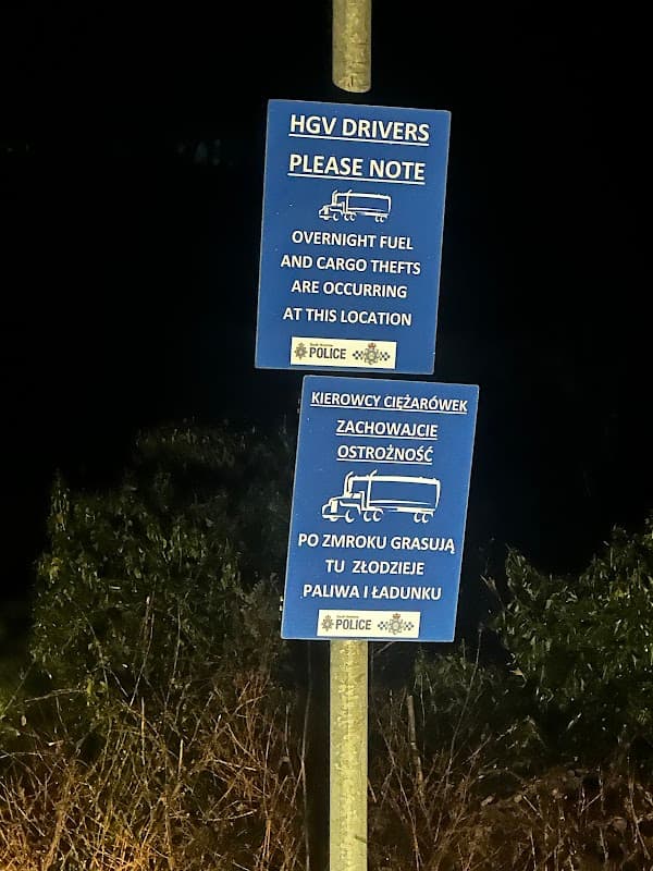 Two blue signs warning HGV drivers about overnight fuel and cargo thefts in Austerfield, Yorkshire.