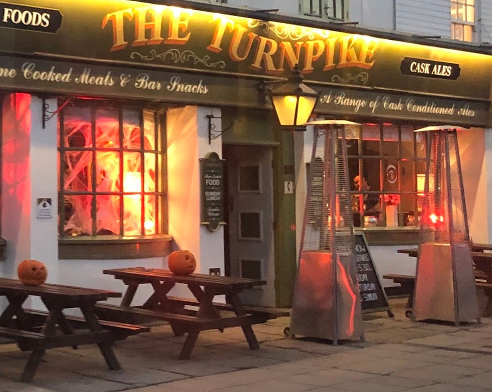 The Turnpike bar features outdoor seating, glowing lanterns, and Halloween pumpkins on tables.