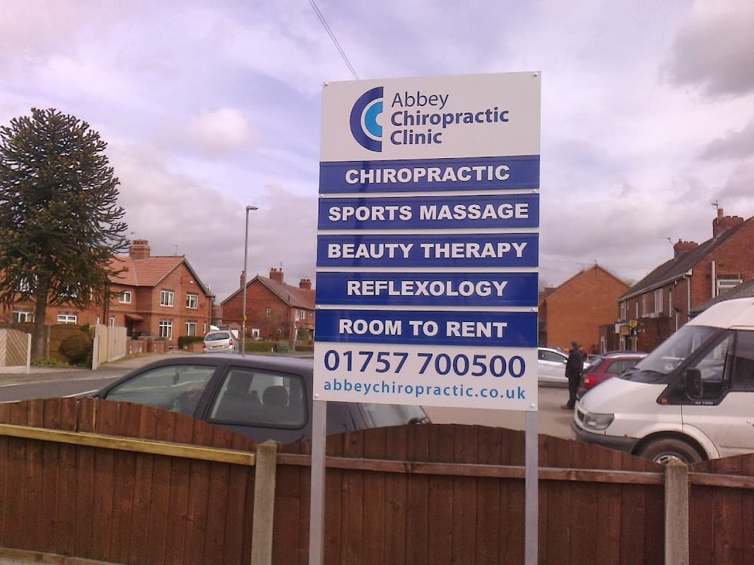 Sign for Abbey Chiropractic Clinic listing services like chiropractic, sports massage, beauty therapy, and reflexology.