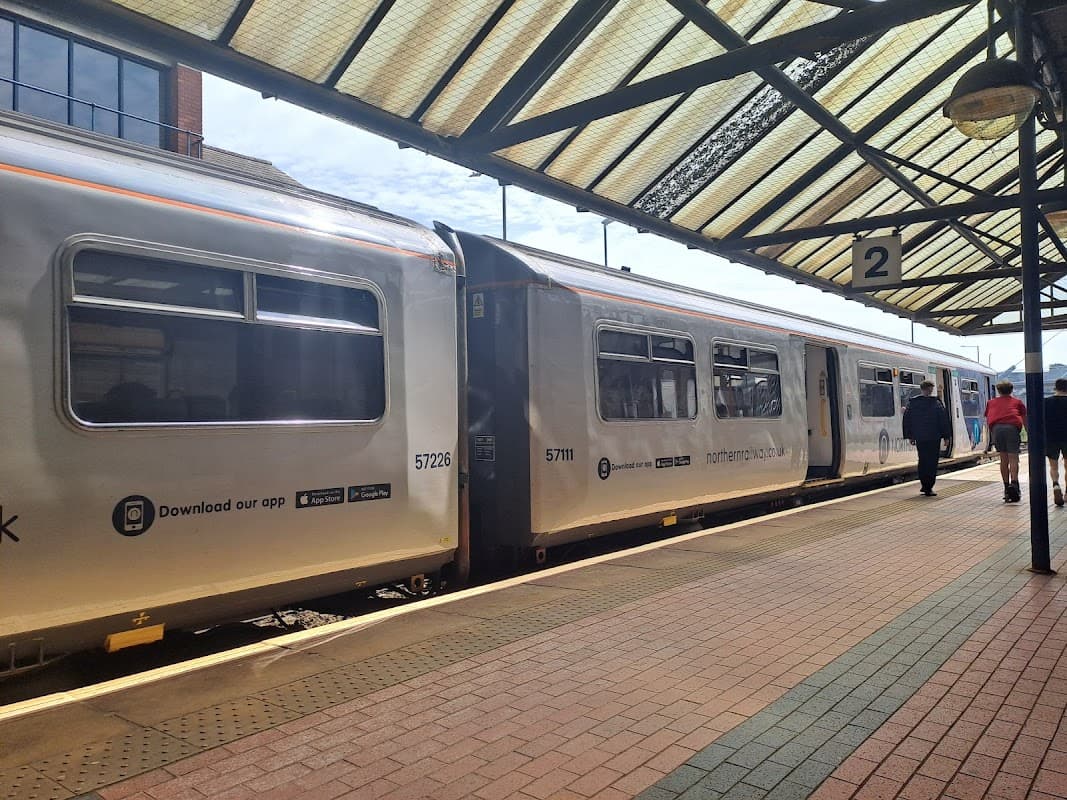 Train at Barnsley station platform, with passengers waiting and a covered roof overhead.