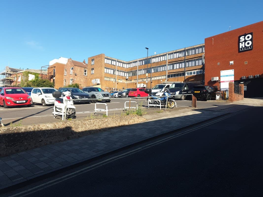 Grahams Orchard car park in Barnsley with parked cars, a building labeled "SOHO," and a clear blue sky.