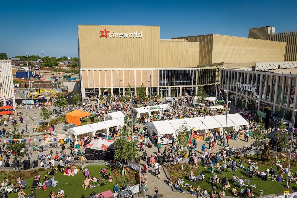 A bustling outdoor market at The Glass Works, with stalls, tents, and crowds enjoying the sunny day in Barnsley.
