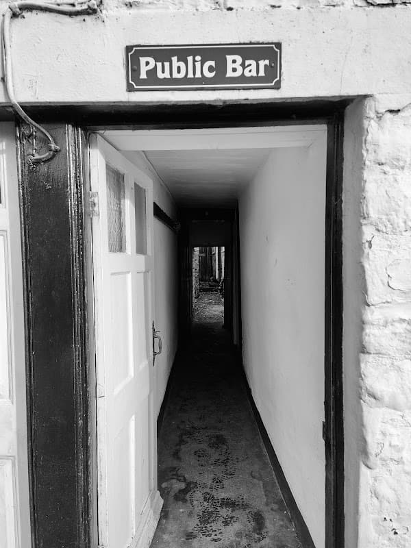 Entrance to Birch Hall Inn with a "Public Bar" sign and a narrow corridor leading inside.