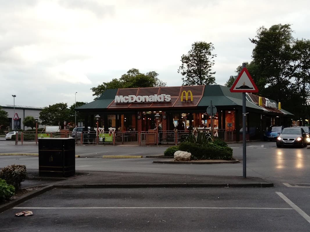 McDonald's restaurant in Bessingby, Yorkshire, with outdoor seating and cars in the parking lot.