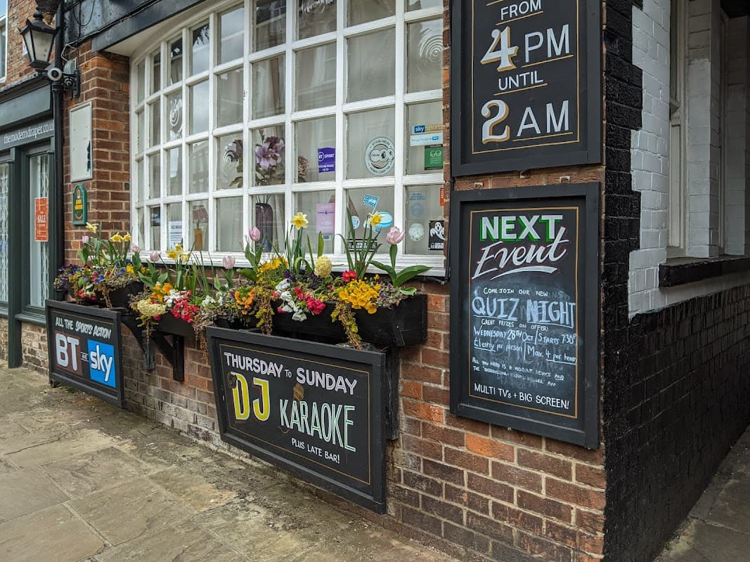 The Beaver pub features flower boxes, event signage, and large windows, inviting guests for karaoke and quiz nights.