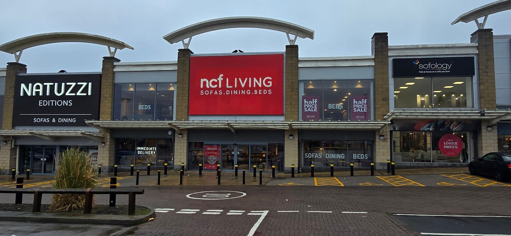 Junction27 shopping center in Birstall, featuring Natuzzi and ncf Living storefronts with promotional signage.