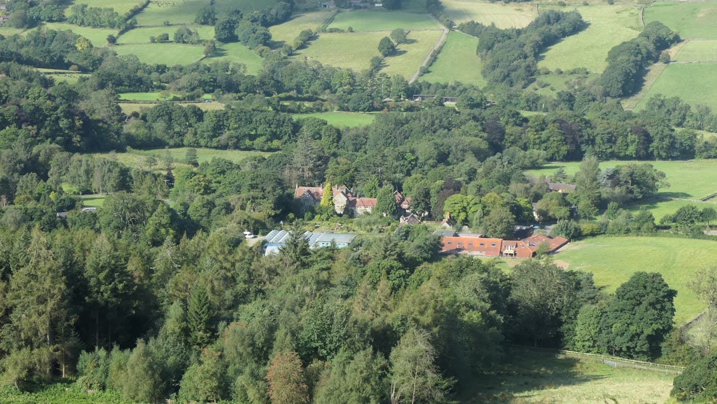 Botton Creamery nestled among lush green fields and trees in the countryside of Botton, North Yorkshire.