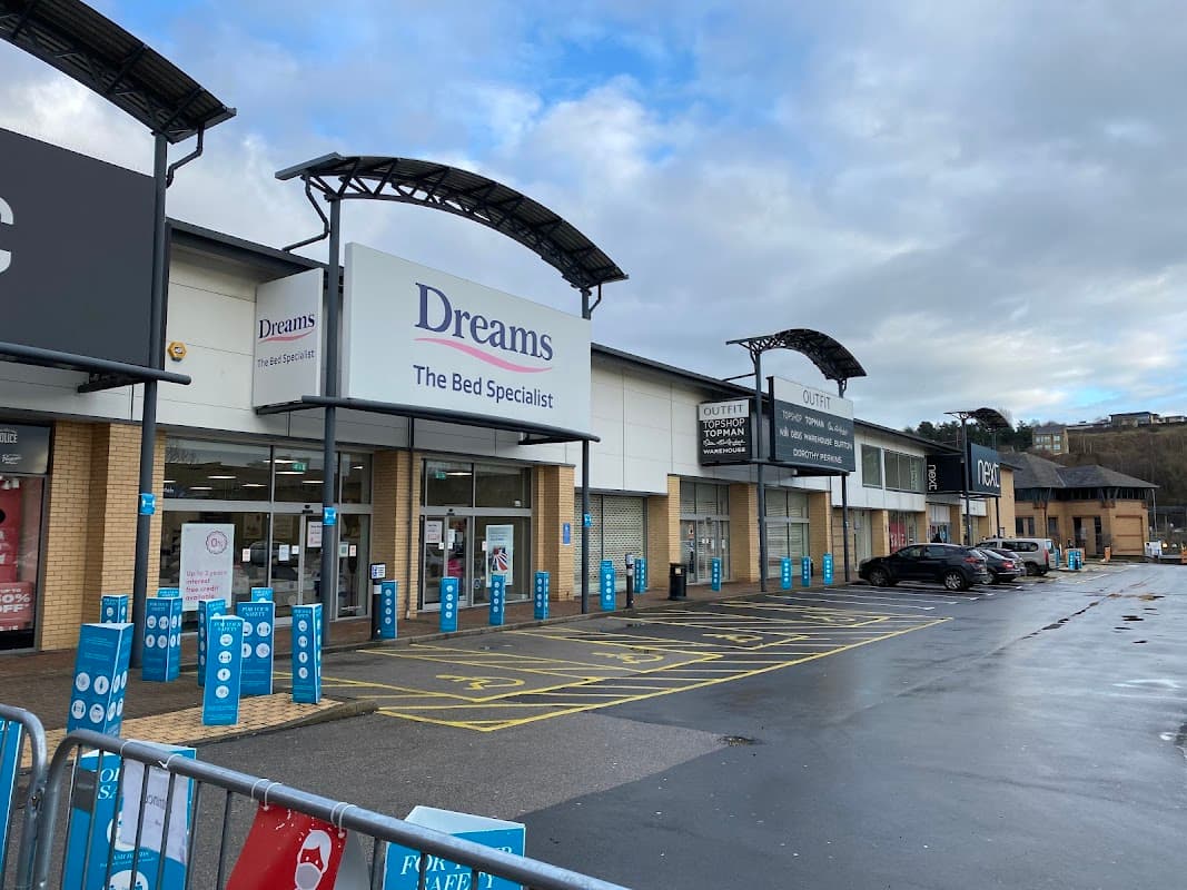 Dreams store front at Forster Square Shopping Park, with parking spaces and cloudy sky in the background.