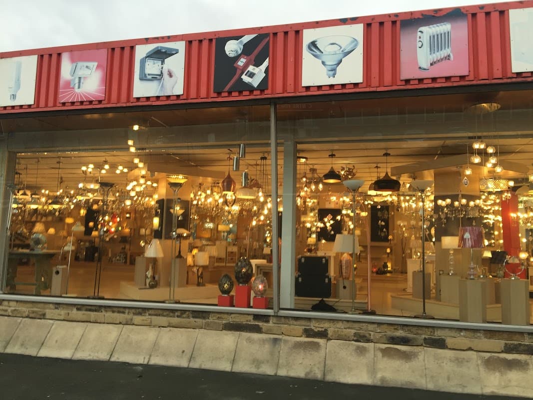 Brightly lit homeware store showcasing various light fixtures and lamps behind large glass windows.