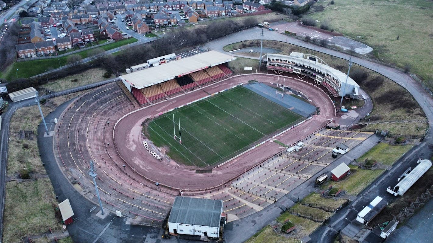 Aerial view of The Provident Stadium featuring a rugby field, seating areas, and surrounding residential buildings.