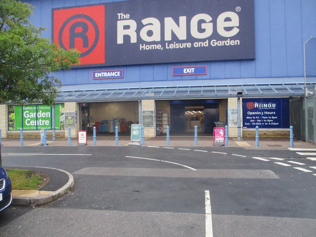 The Range store exterior with entrance and exit signs, blue barriers, and promotional banners for the garden center.