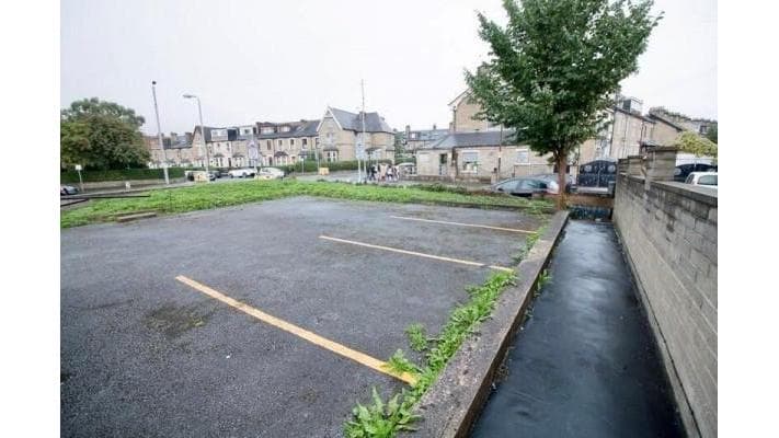 Pay & Display parking area in Bradford, Yorkshire, with empty spaces and greenery along the edges.