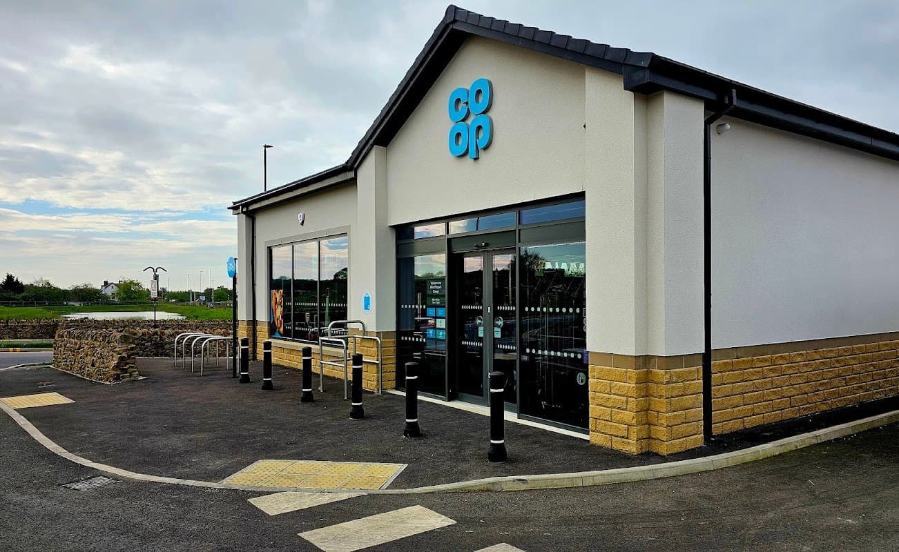 Co-op Food store with large windows, blue signage, and bike racks outside, set in a rural area of Bramhope, Yorkshire.