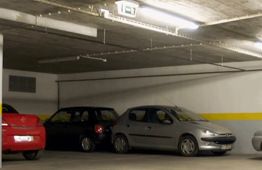Pay & Display parking area with parked cars, yellow wall stripe, and overhead lighting in Bramhope, Yorkshire.
