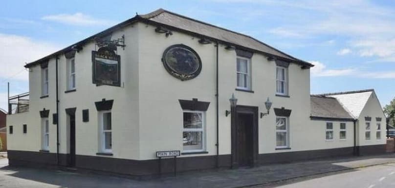 The Black Bull B&B, a cream-colored building with a sign and decorative features, located in Burton Pidsea, Yorkshire.