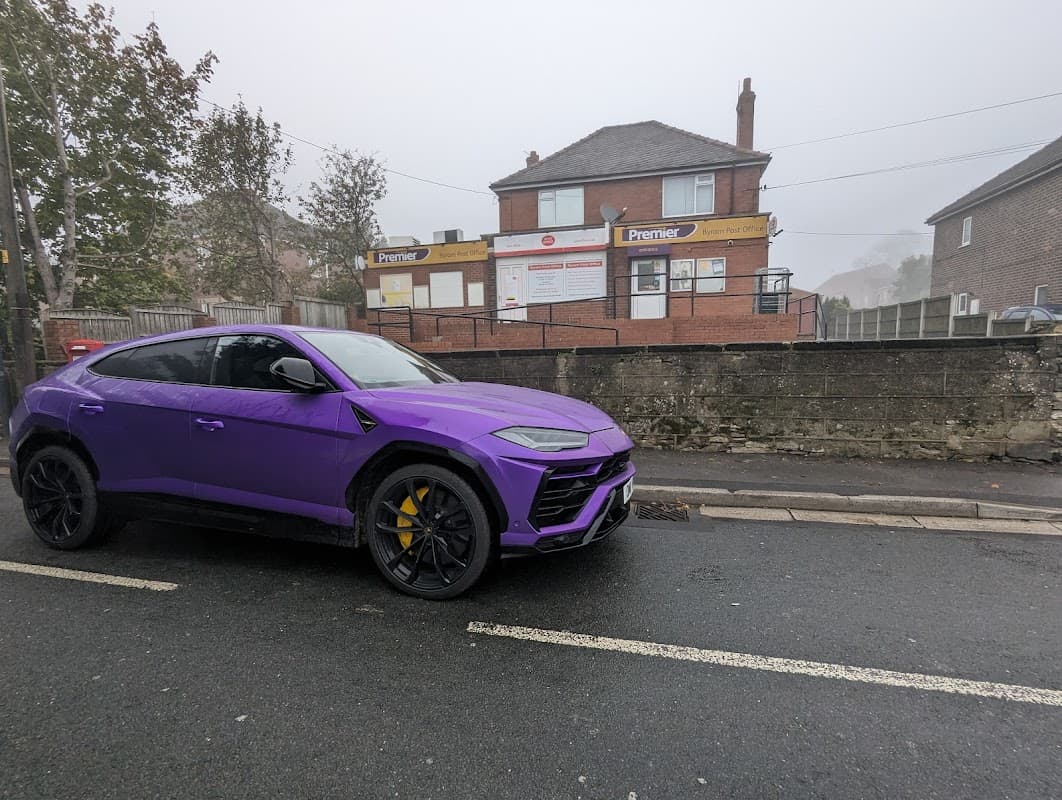 Purple SUV parked on the street in front of Byram Post Office and Premier Store, shrouded in fog.