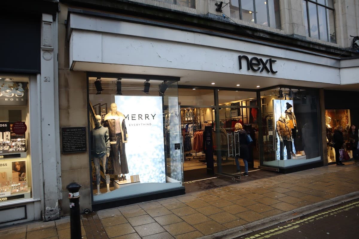 Next store front in North Yorkshire, featuring mannequins in festive attire and large promotional displays.