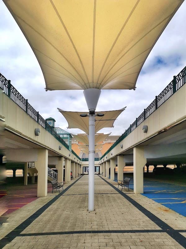 Covered walkway with large fabric canopies, leading through a multi-level car park at Meadowhall shopping centre.