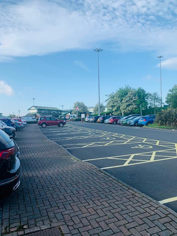 Park & Ride lot with parked cars, clear blue sky, and greenery in the background at Meadowhall, Carbrook, Yorkshire.