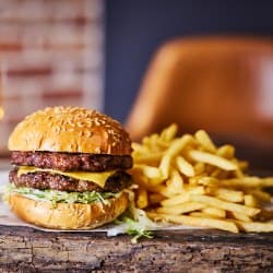 A juicy double cheeseburger with lettuce and cheese, served with a side of golden French fries.