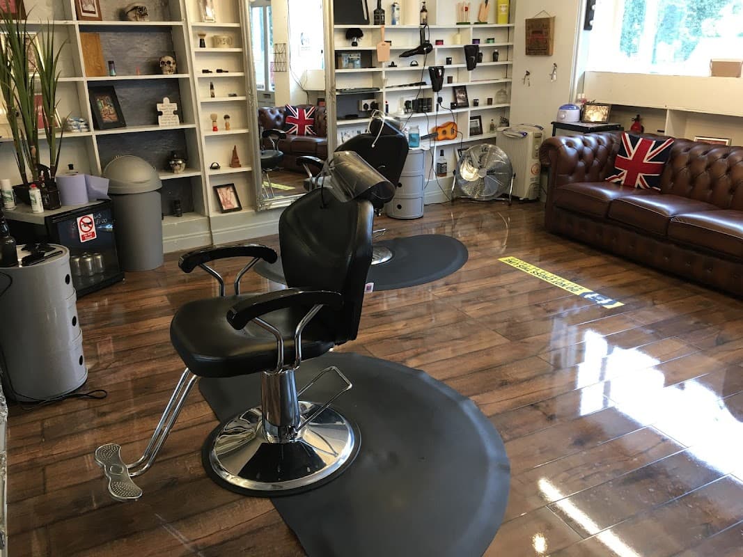 Stylish hair salon interior with a black barber chair, wooden floor, and British flags on display.