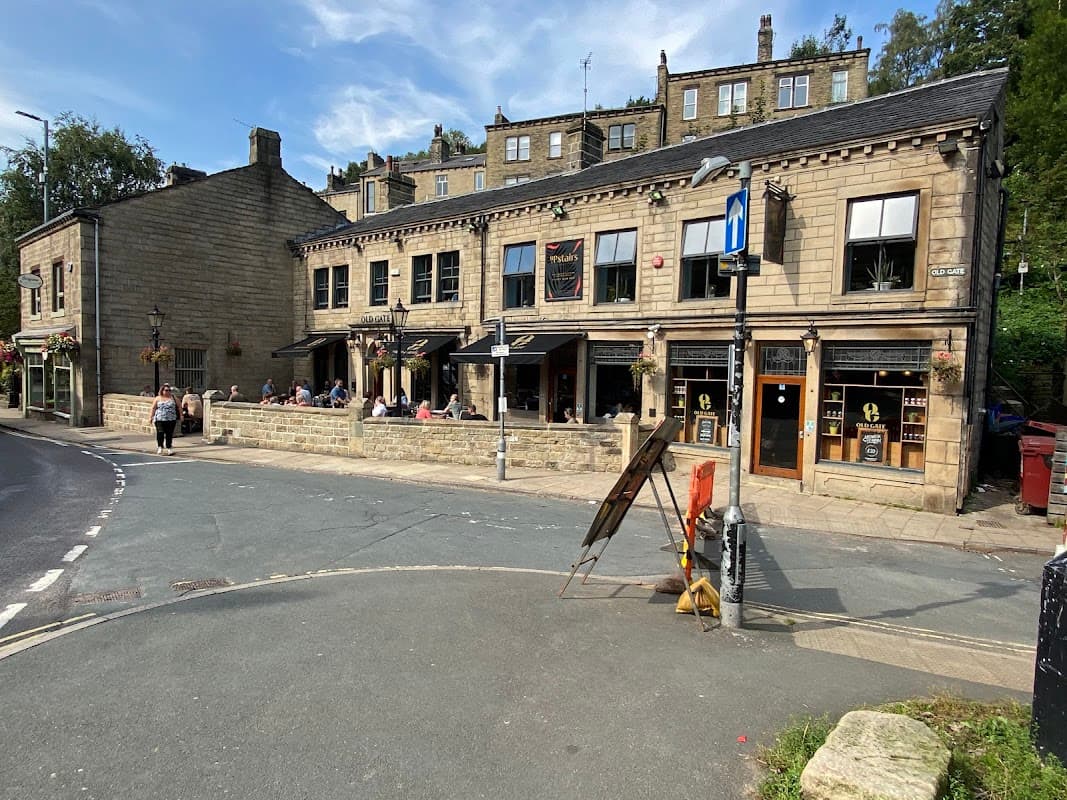 St. Georges Square car park with a stone building, outdoor seating, and pedestrians in Chiserley, Yorkshire.