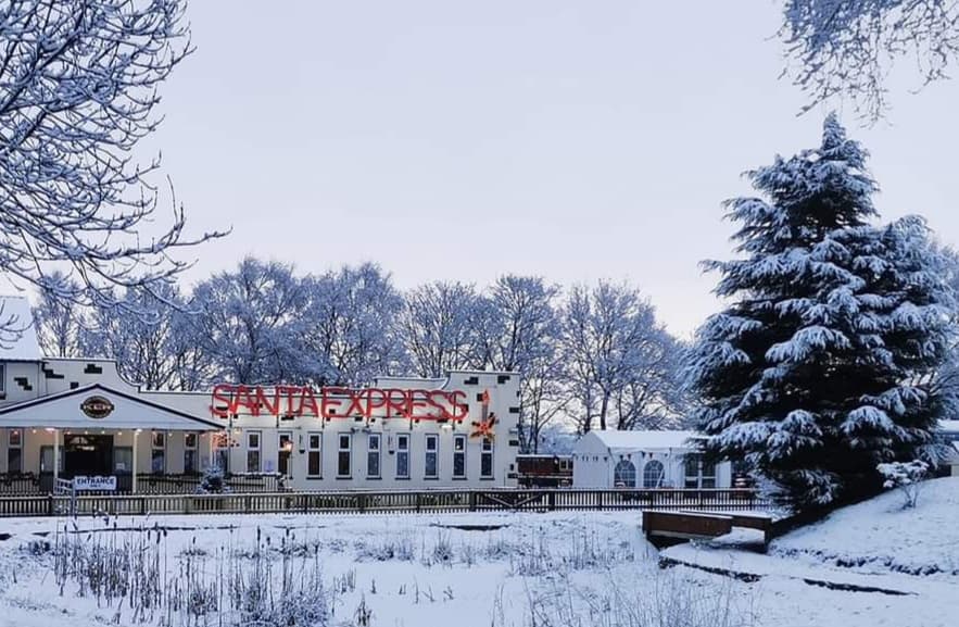 Whistlestop Valley cafe with snow-covered trees and a "Santa Express" sign in a winter landscape.