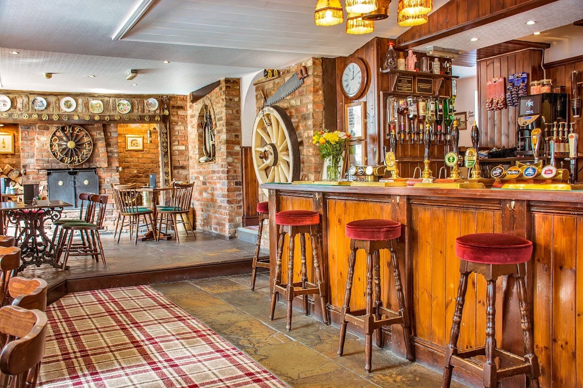 Warm wooden bar with red stools, dartboard, and rustic decor in a cozy pub setting.