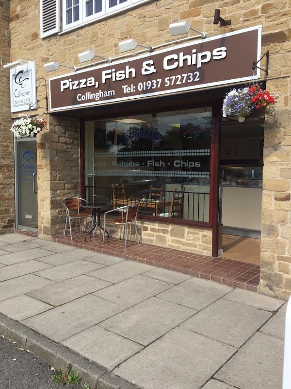 Restaurant exterior featuring a sign for "Pizza, Fish & Chips," with outdoor seating and stone facade in Collingham.
