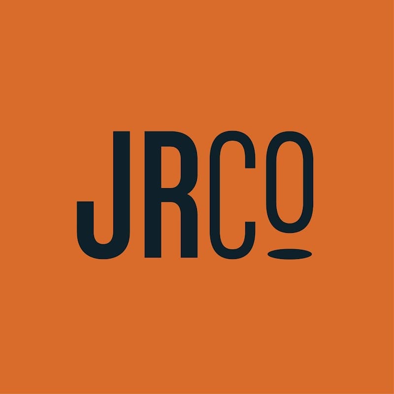 Bold black "JRCo" logo on an orange background, featuring a stylized letter "o" with a circular design.