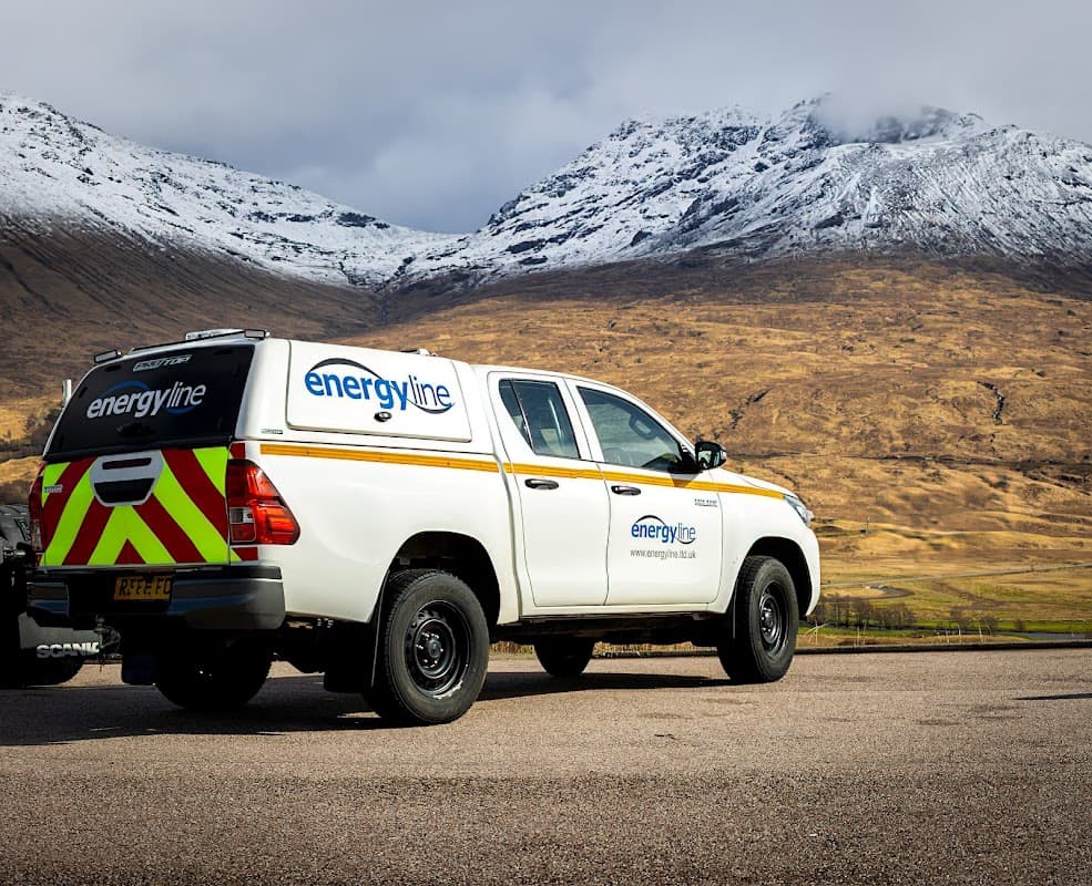 Energyline Limited truck parked with snow-capped mountains and a golden landscape in the background.