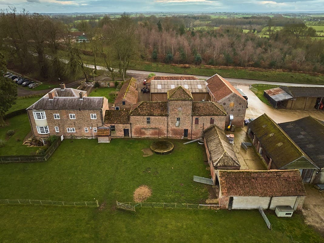Aerial view of Cundall Lodge Farm featuring buildings, green fields, and a gravel path in North Yorkshire.