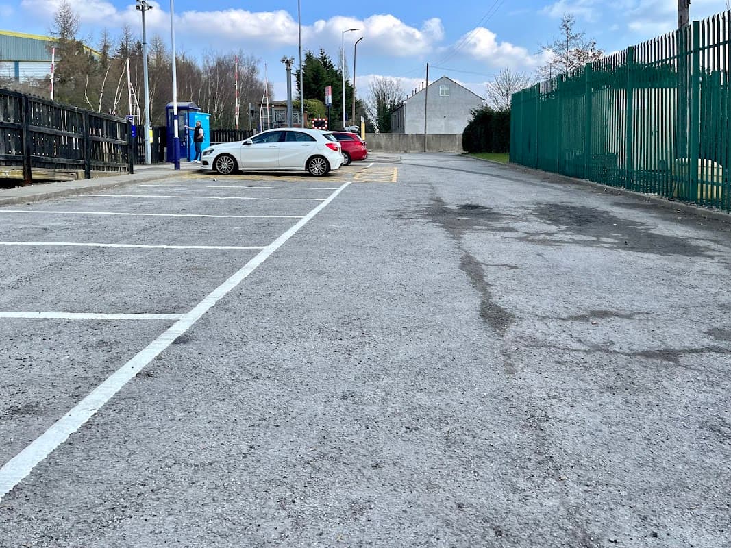 Free parking area at Dodworth Station, featuring several empty spaces and a few parked cars against a clear sky.