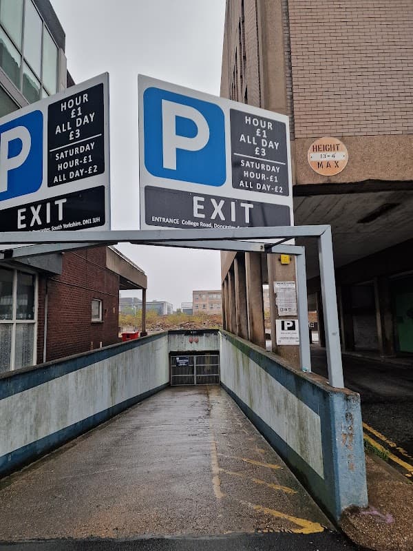 Signage indicating parking rates and exit, with a ramp leading into a multi-story car park in Doncaster.