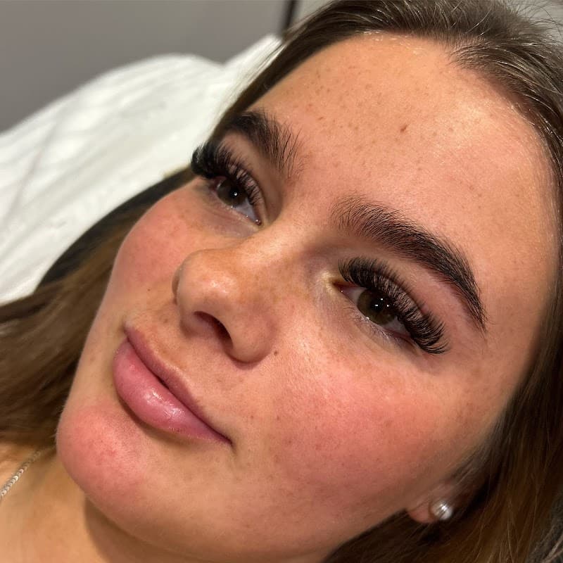 Close-up of a woman with long eyelashes and well-groomed brows, showcasing a beauty treatment at Glow Up Lash and Brow Lounge.
