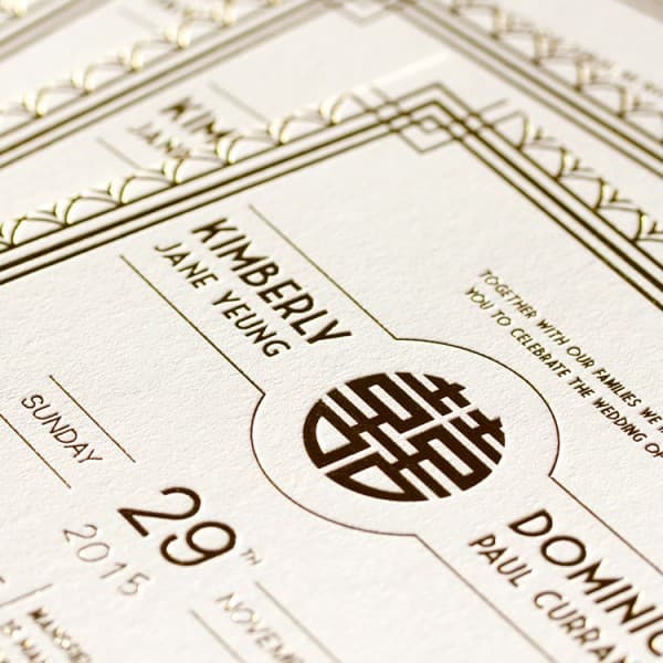 Elegant wedding invitation featuring gold accents, ornate patterns, and names in stylish typography.